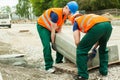 Workers heaving block of setts Royalty Free Stock Photo