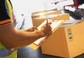 Workers Holding Clipboard is Checking Packaging Boxes on Conveyor Belt. Cartons, Cardboard Boxes. Warehouse Inventory Management. Royalty Free Stock Photo