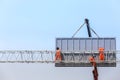 Workers install big steel billboard over highway