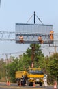 Workers install big steel billboard over highway