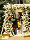 Workers install festive floral arch for the wedding