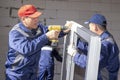 Workers install glazing in a house under construction Royalty Free Stock Photo