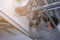 Workers installers make a ventilation system indoors under the ceiling, the front and background are blurred with a bokeh effect Royalty Free Stock Photo