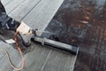 Workers installing bituminous membrane waterproofing insulation with blowtorch