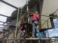 Workers are installing bracing steel beam of steel structure work at industrial factory