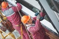 Workers installing glass window on building