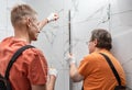 Workers are installing a silicone gasket seal in the shower enclosure