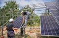 Workers installing solar panel on metal beams Royalty Free Stock Photo