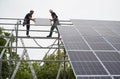 Workers installing solar panels on metal beams Royalty Free Stock Photo
