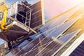 Workers installing solar panels on private home hexagonal roof felt on sunny day  blue sky. Royalty Free Stock Photo