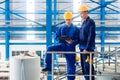 Workers in large metal workshop checking work