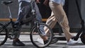 Workers legs walking downtown with electric scooter bicycle in hands close up.