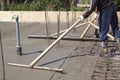 workers leveling fresh concrete slab with a special wooden working tool Royalty Free Stock Photo