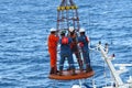 Workers are lifted by the crane to the offshore platform