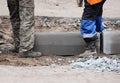 Workers are lifting concrete curb. Concrete kerb installation at sidewalk edging. Sidewalk replacement Royalty Free Stock Photo