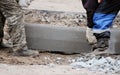 Workers are lifting concrete curb. Concrete kerb installation at sidewalk edging. Sidewalk replacement Royalty Free Stock Photo