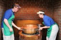 Workers lifting large copper pot with melted chocolate for fudge,Pepper Lane Fudge & Sweets,Intercourse,Pa,2013