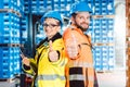 Workers in logistics distribution center showing thumbs-up