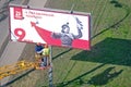 Workers look at a roadside poster for the victory day in world war 2 - Moscow, Russia, 21.04.2020