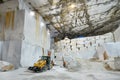 Workers and machinery inside a marble quarry