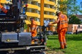 Workers make blacktop. New asphalt is laid over the old asphalt at the intersection, filling in several potholes in the