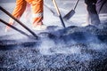 Workers making asphalt with shovels