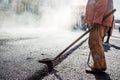 Workers making asphalt with shovels at road