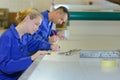 Workers marking position to cut material