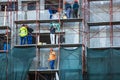 Workers on metal scaffoldings renovating the exterior of apartment building. Bucharest, Romania, 2020