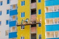 Workers on a mobile platform insulate the walls of the house with mineral insulation