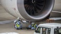 Mechanics working on Jet engine on tarmac Royalty Free Stock Photo