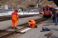Workers in orange uniform repair railroad , Switzerland Royalty Free Stock Photo