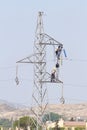 Workers over a high tension tower making reparations. Royalty Free Stock Photo