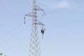 Workers over a high tension tower making reparations. Royalty Free Stock Photo