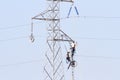 Workers over a high tension tower making reparations.