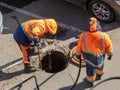 Workers over the open sewer hatch