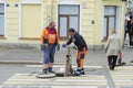 Workers in overalls install a hydrant and attach a hose