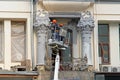 Workers paint columns with stucco on the facade of the house on Tverskaya in Moscow.