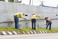 Workers paint white color on the road