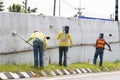 Workers paint white color on the road