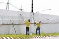 Workers paint white color on the road