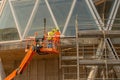 Workers on a platform in mobile safety while installing the electrical system at the bibioteca del bosco in the isola district of