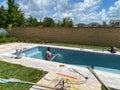 Workers from a pool finishing company spraying plaster finish on the interior of a swimming pool