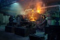 Workers pour molten metal at steel foundry. Industrial team in protective gear casting, manufacturing in heavy industry Royalty Free Stock Photo