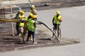 Workers pouring concrete construction site