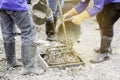 Workers are pouring concrete out of the tank to make a pile casting