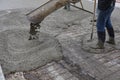 Workers pouring wet concrete using concrete bucket. Industrial construction