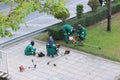 Workers are preparing and refueling of lawn mower on the roadside.