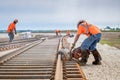 Workers in the process of railroad track construction - rail saw with hardhat and safety gear