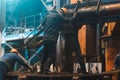 Workers in process of work with large mold iron cast on steel mill. Foundry workshop interior. Typical metallurgical